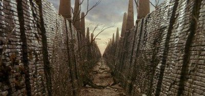 A brick corridor stretches off into the distance. Ferns grow from the brickwork and roots stretch across the path.